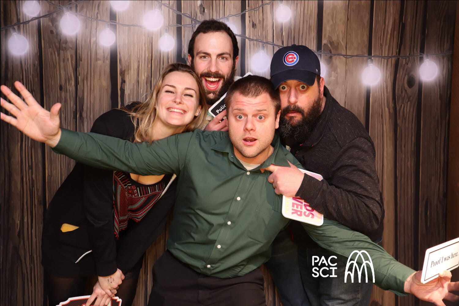 Group laughing at rustic wood backdrop with string lights at Classic Photo Booth