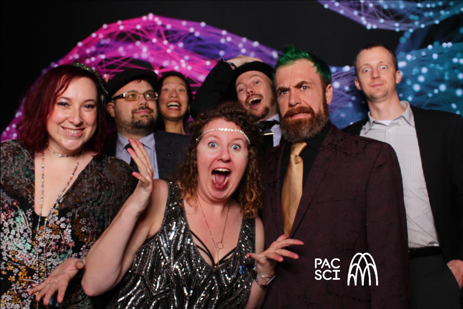 Friends laughing together at vintage photo booth with sparkling fiber optic backdrop