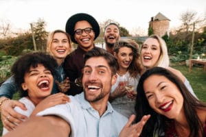 Group of friends laughing together for an outdoor selfie-style photo