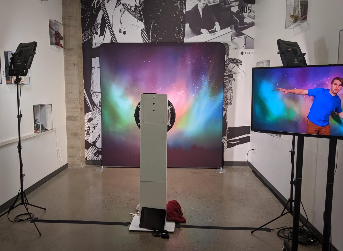 Orbit 360 photo booth with aurora backdrop and live playback monitor in gallery