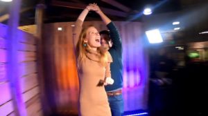 Woman mid-spin on Orbit 360 photo booth platform inside venue