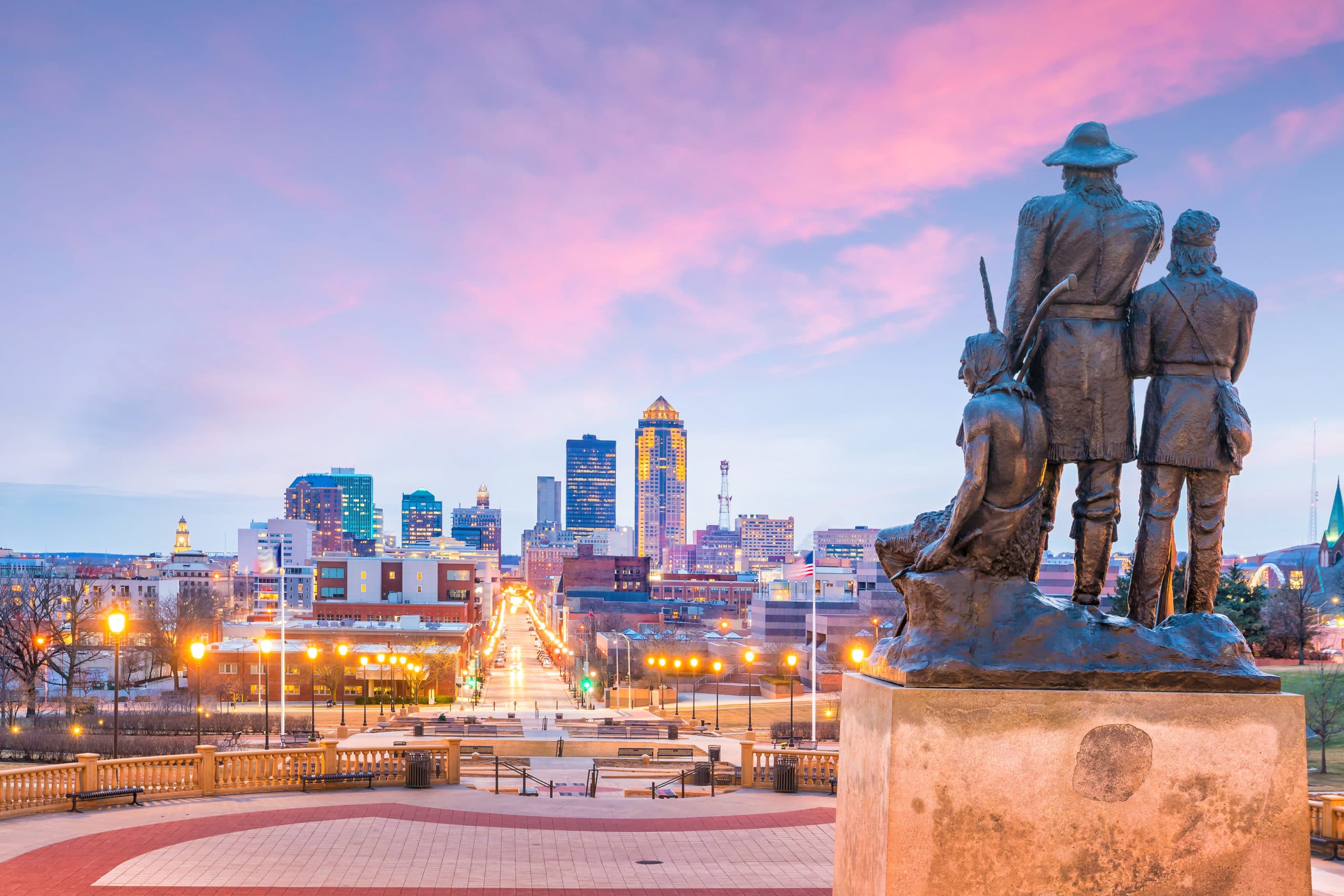 Des Moines Iowa downtown skyline at dusk with pioneer monument in foreground