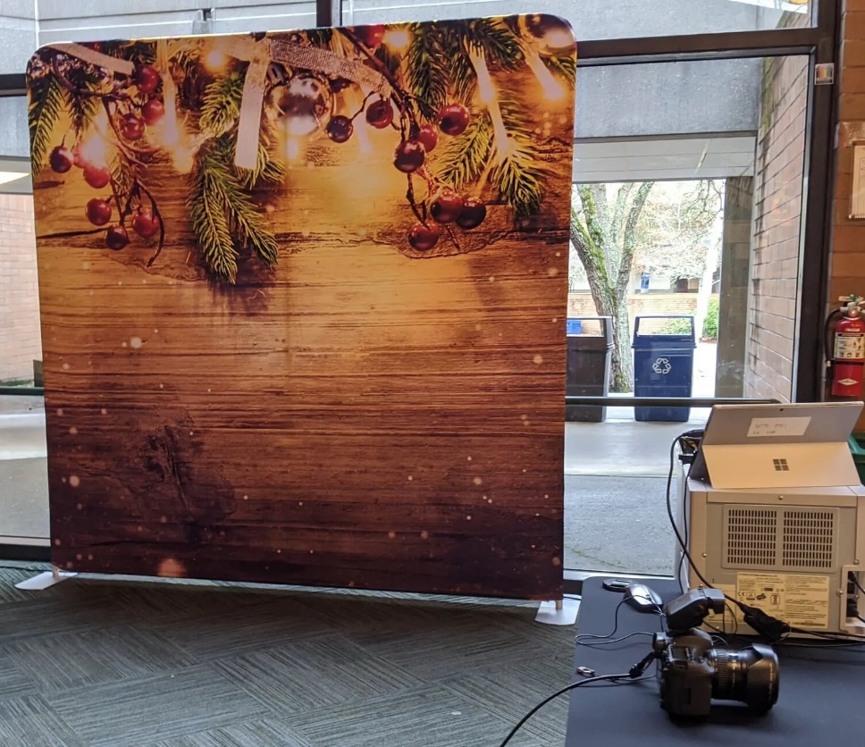 Popup Studio Photo Booth with rustic wood and pinecone holiday backdrop indoors