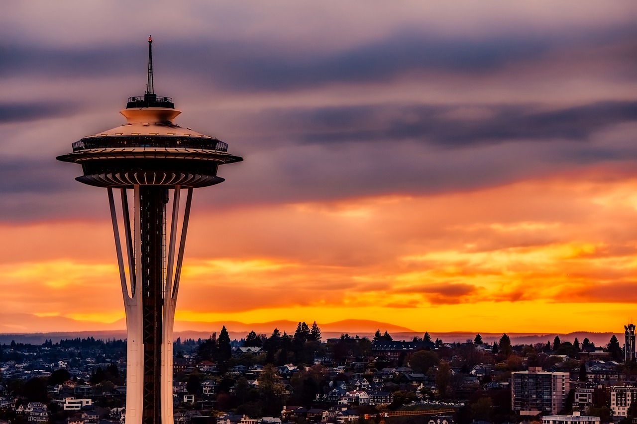 Seattle Space Needle silhouetted against orange sunset sky over the city