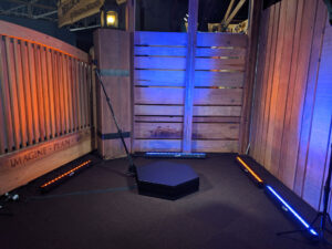 Empty Orbit 360 photo booth platform with rustic wood backdrop and LED lighting
