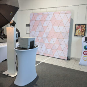 Classic Photo Booth station with pink geometric backdrop in event hall