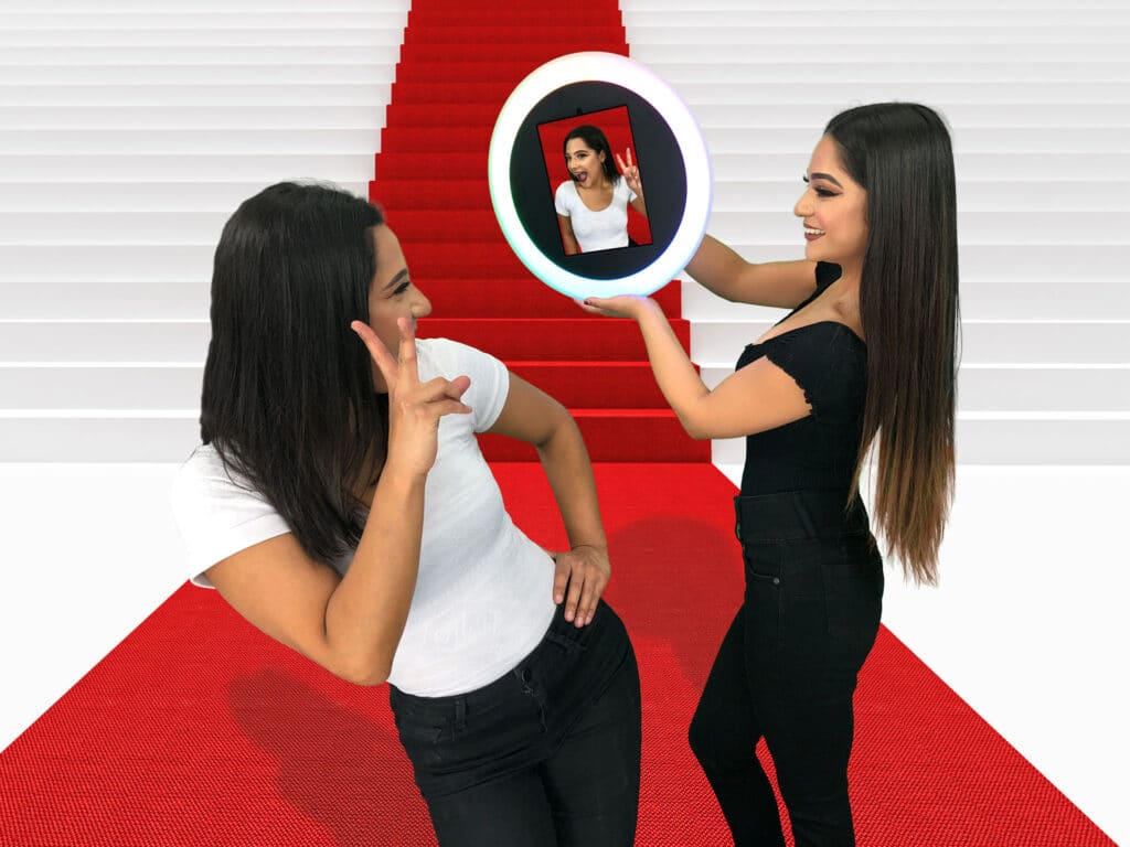 Two women on red carpet with Freeform Roaming Booth ring camera display
