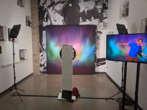 Slow motion booth setup with aurora backdrop and live monitor in gallery space