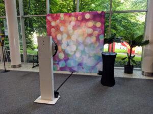 Social Booth with bokeh backdrop set up in glass-walled corporate atrium