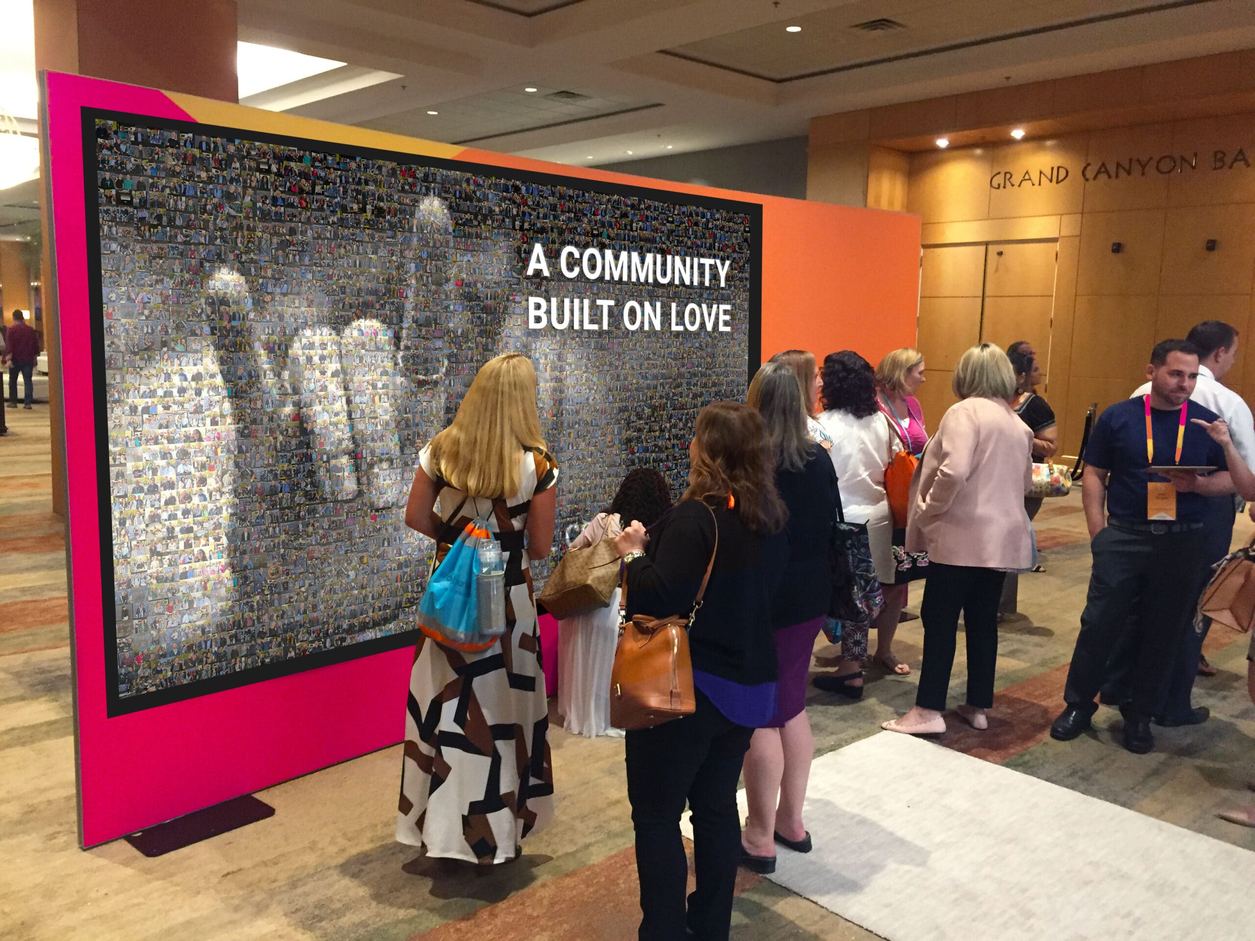 Guests viewing colorful Wall Mosaic display reading A Community Built On Love