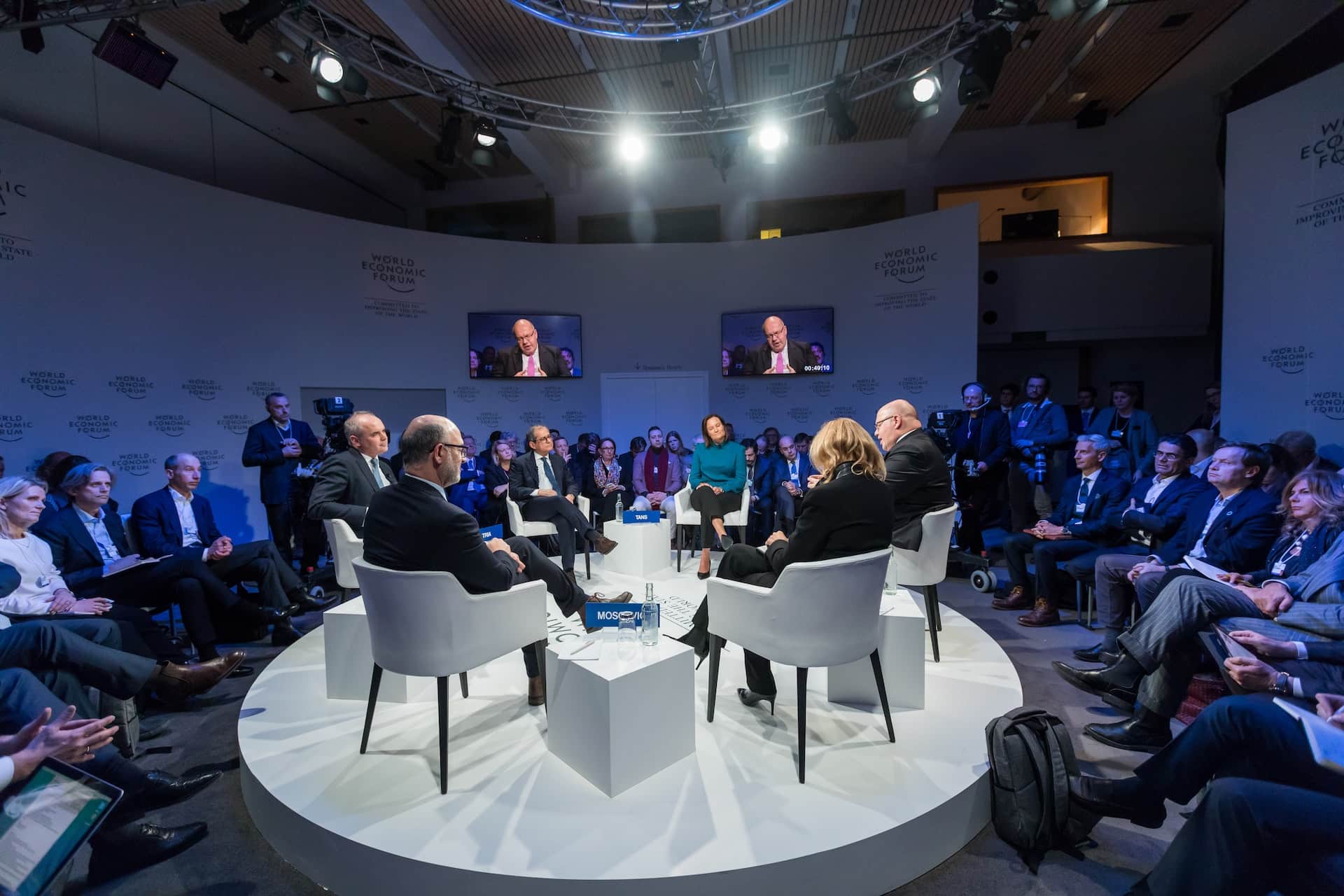 Round panel discussion stage with seated speakers at corporate conference event