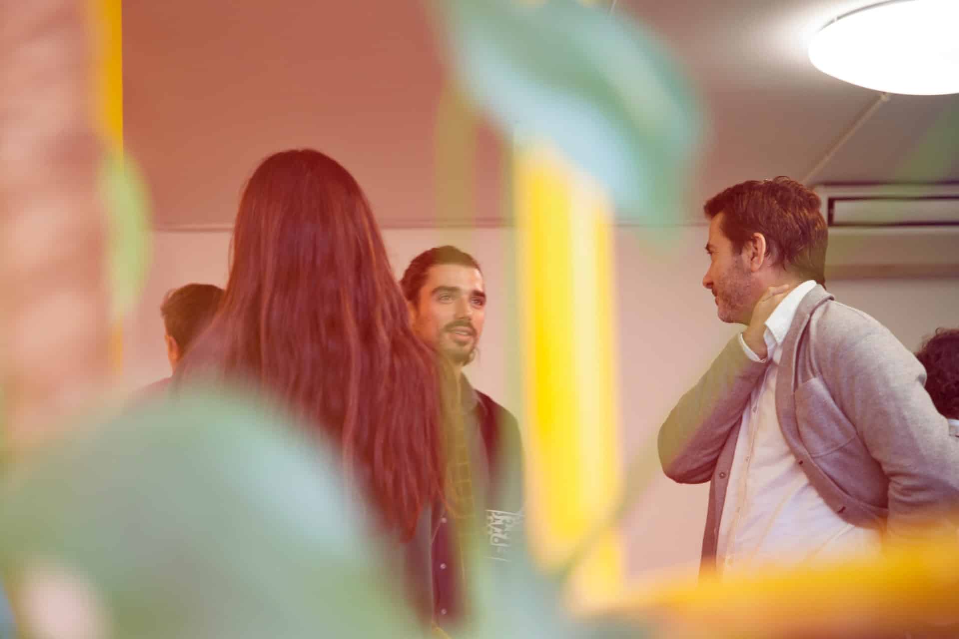 Group mingling at corporate event with green plants and yellow accents