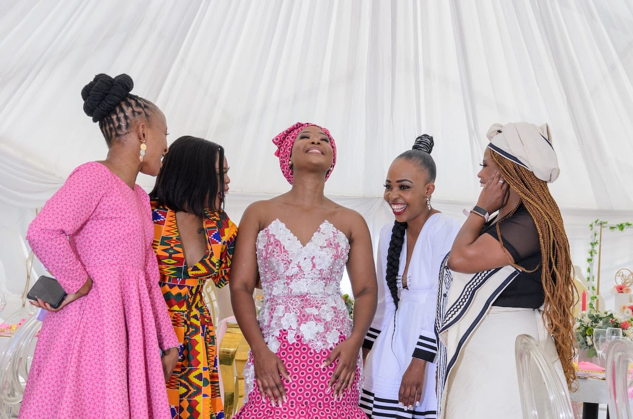 Group of women in traditional African attire celebrating bride at wedding