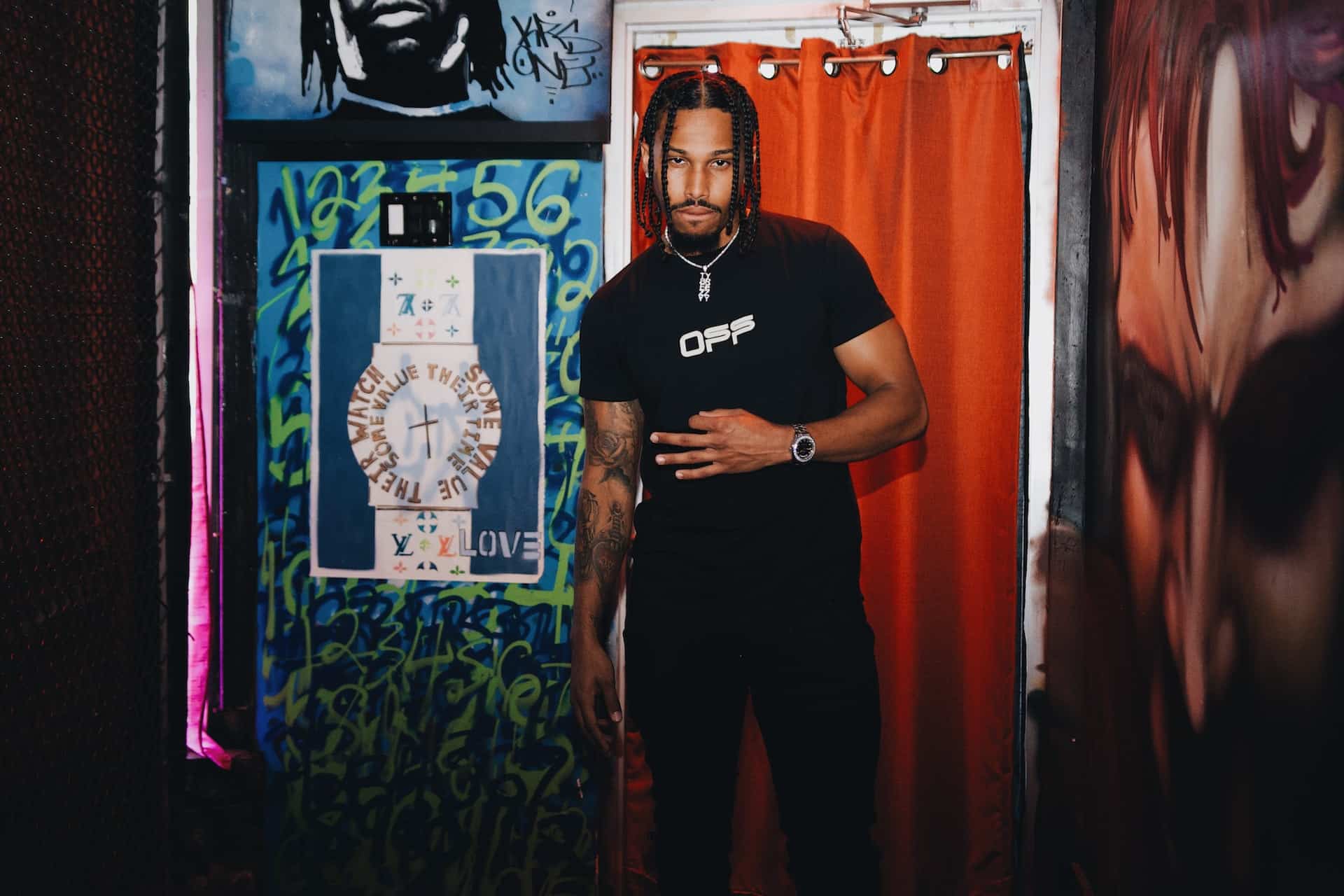 Man posing in graffiti-walled hallway near vintage photo booth