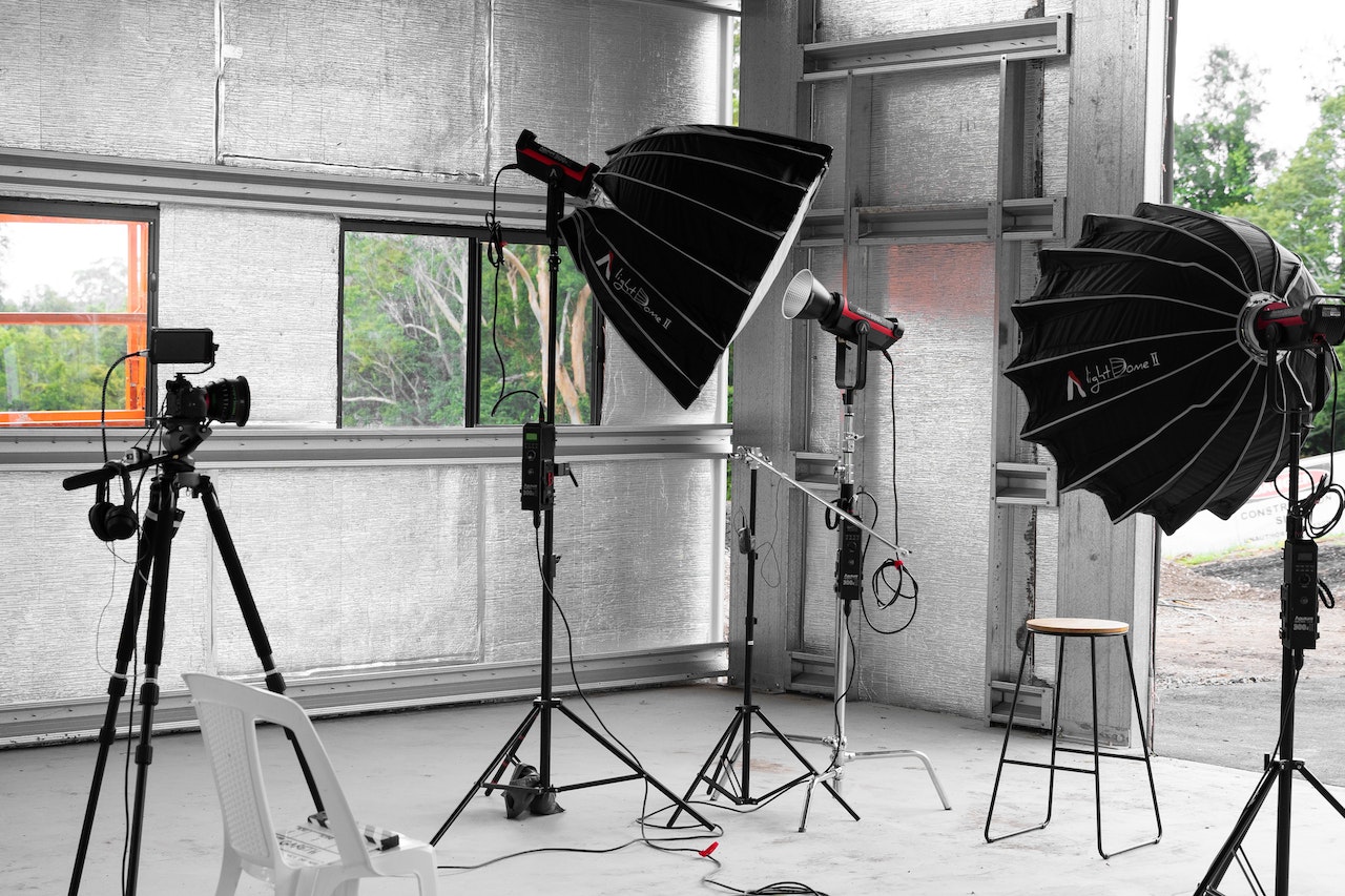Empty professional photo studio with backdrop, lights and cameras on tripods