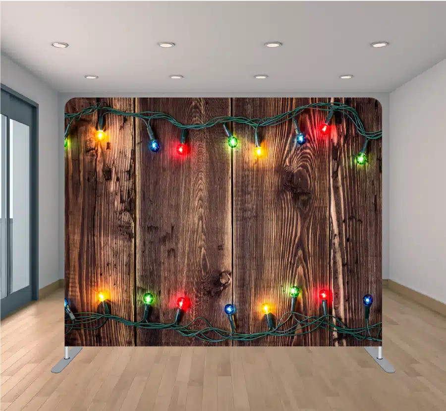 Rustic wood plank photo booth backdrop strung with warm Christmas lights