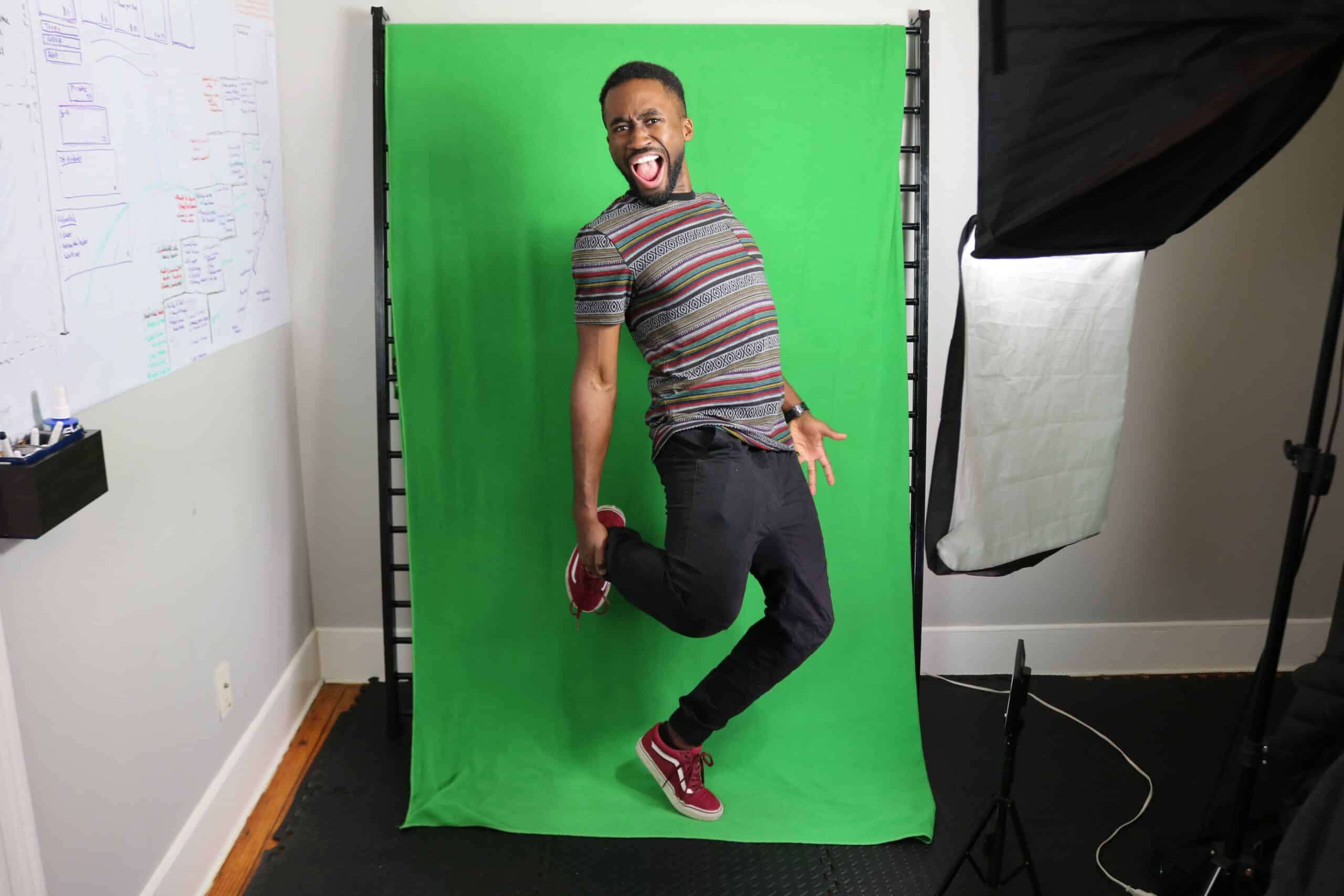 Man jumping playfully against green screen photo studio backdrop