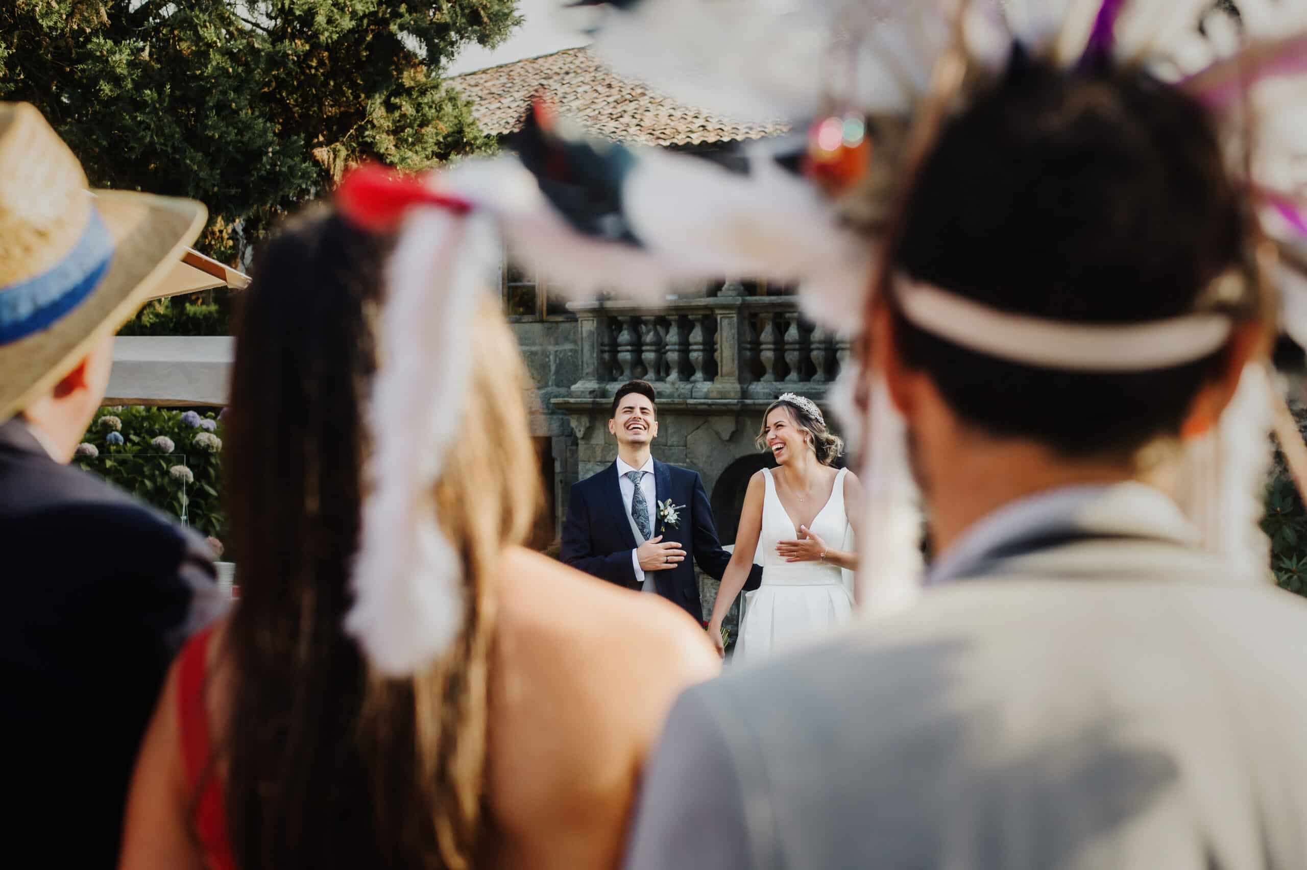 Bride and groom kissing surrounded by guests wearing playful disguises