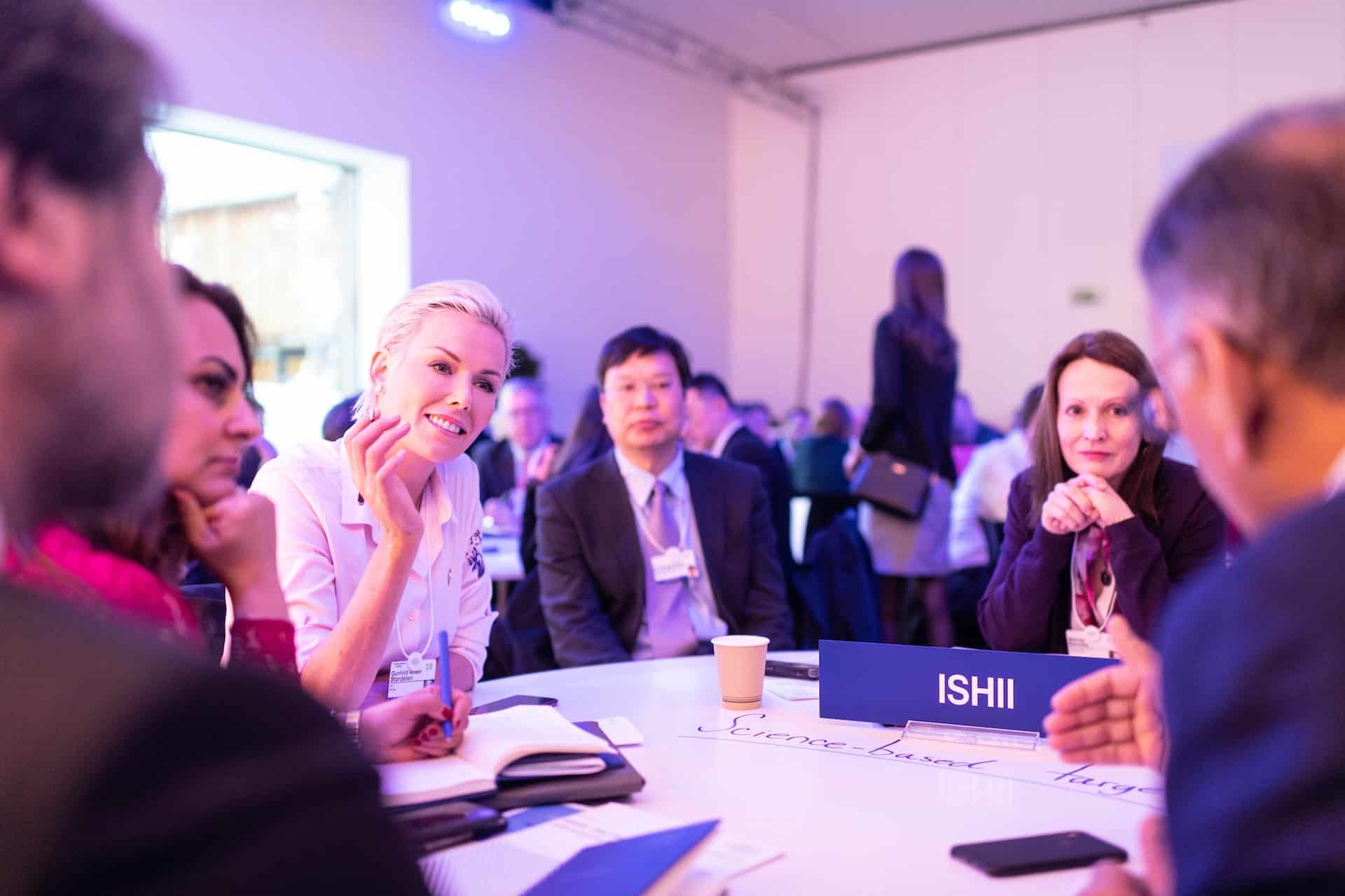 Corporate roundtable discussion with attendees talking at conference event