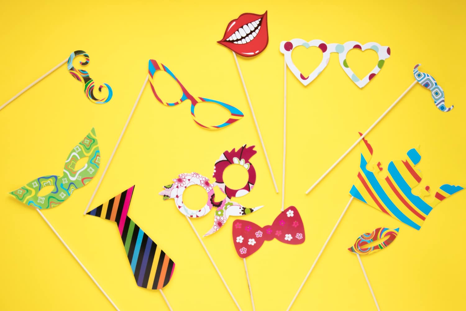 Assortment of paper photo booth props including mustaches glasses and bow ties
