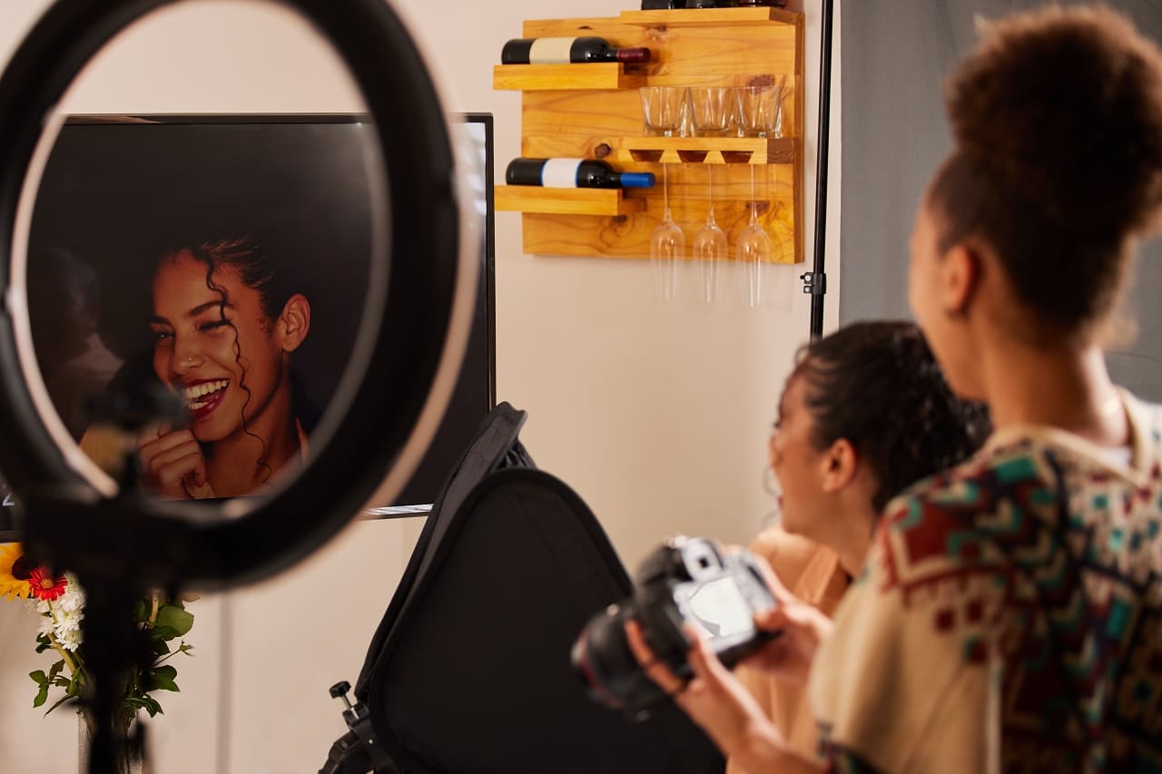Photographer setting up ring light and camera in front of yellow backdrop